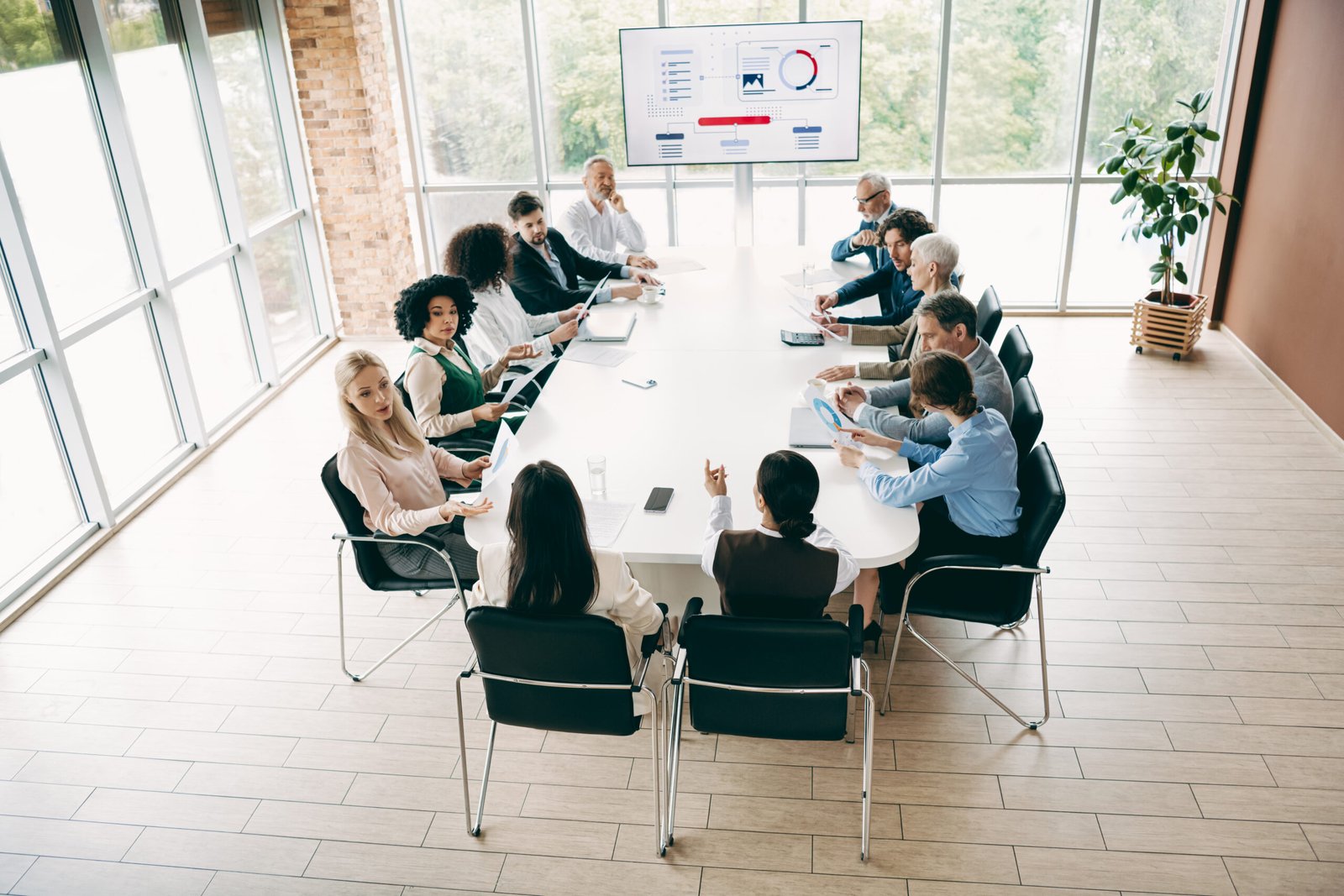Diverse team conducting a business meeting in a modern office with coworkers collaborating and sharing ideas during a presentation